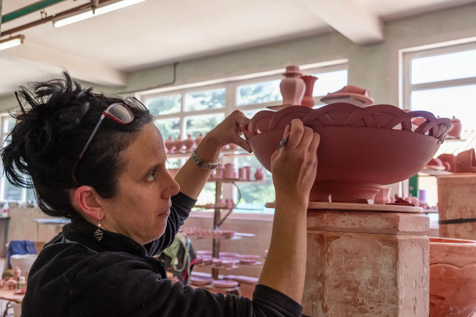 Artisane décorant minutieusement une pièce dans son atelier