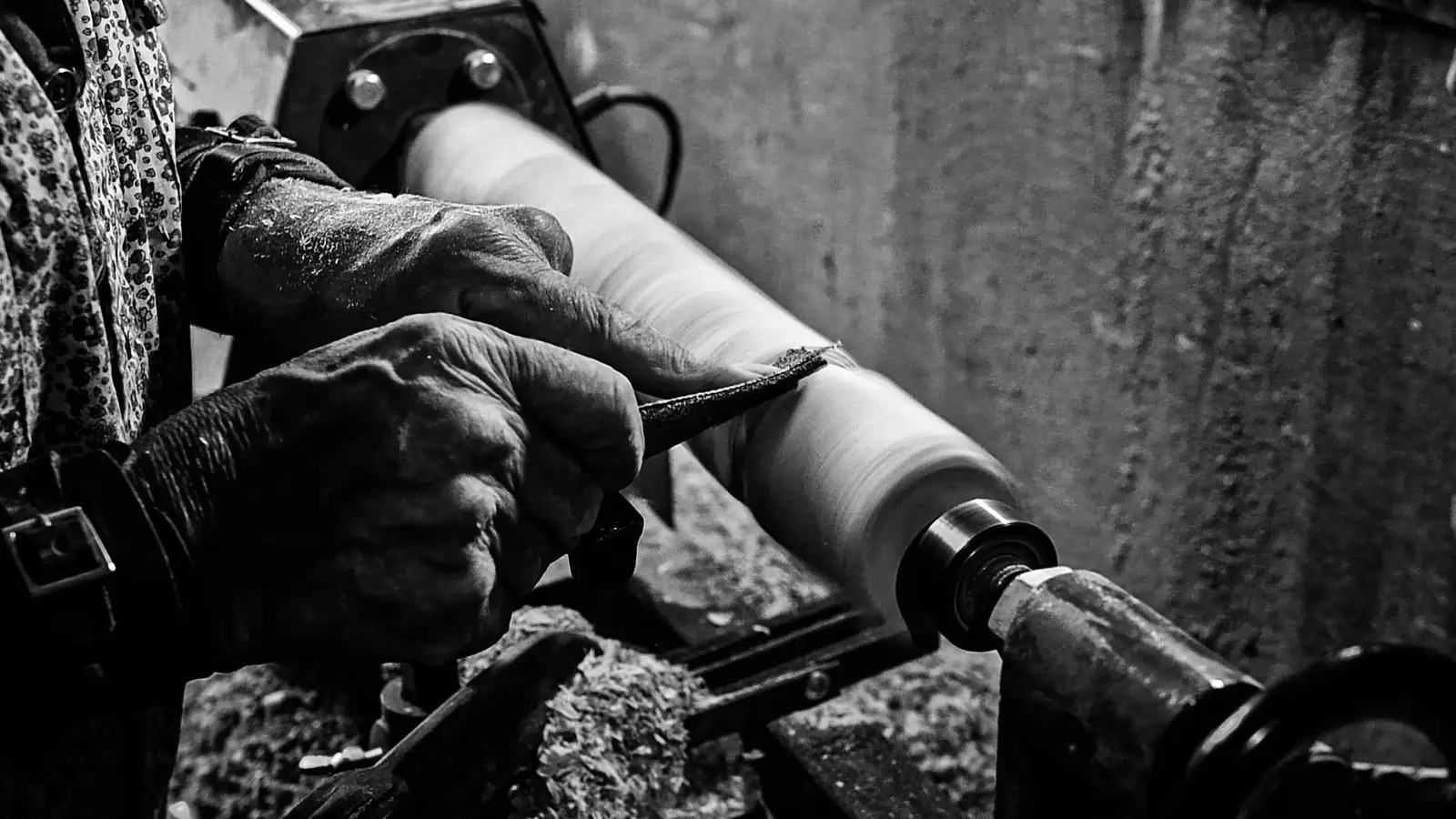 Mains d’un tourneur façonnant une pièce de bois