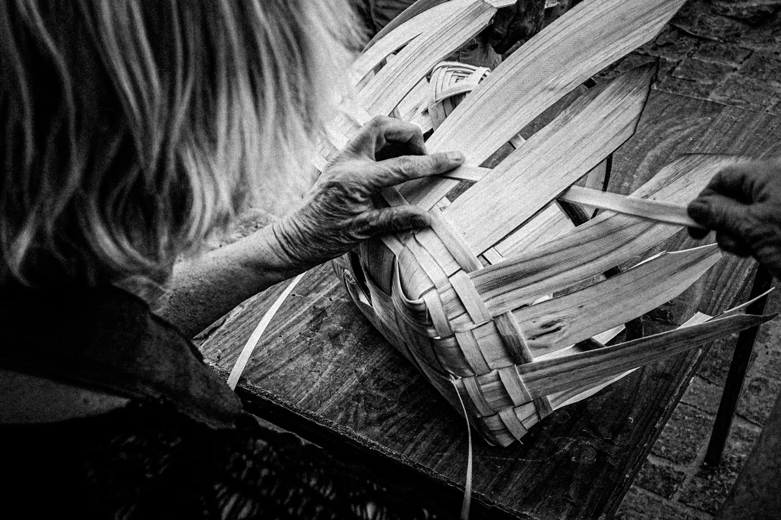 Vannière tressant les fibres d’un panier